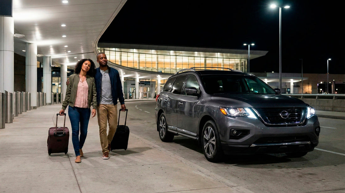 Couple walking with luggage towards their grey Nissan Pathfinder rental car at night at the airport.