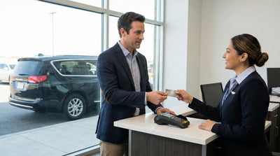 Customer handing a credit card to an agent for pre-authorisation at a rental desk.