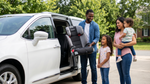 A family prepares to load a booster seat into a rental minivan in Pennsylvania, following local rules.
