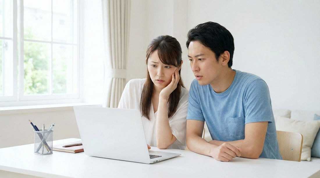 A couple looks worried at a laptop screen, researching car rental requirements and credit checks.
