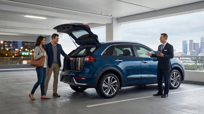 A modern car rental parked on a city street with the iconic New York skyline in the background