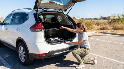 A car hire pulled over with a flat tire on the shoulder of a long, straight road in West Texas