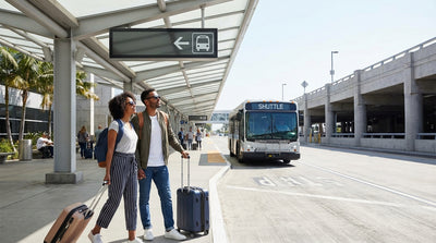 A car hire shuttle bus waits for passengers under palm trees at the sunny San Diego Airport in California