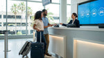 Travelers with luggage wait for a shuttle at the Los Angeles airport car rental center