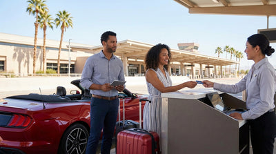 A modern car rental driving down the Las Vegas Strip at night, surrounded by the bright lights of the casinos