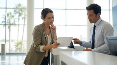 A red convertible car hire driving down a scenic, palm-lined coastal road in sunny Florida