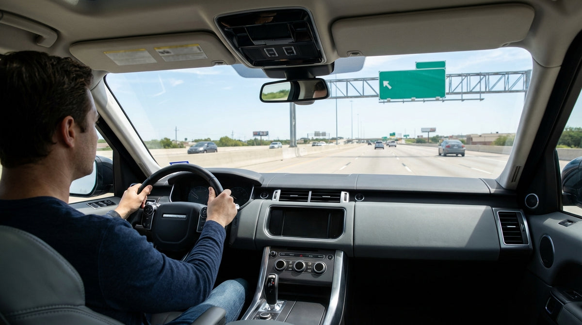View from a car hire approaching a complex freeway interchange with overhead signs in Texas