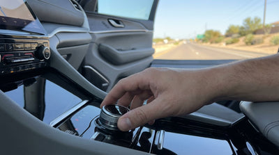 A driver's hand using a modern rotary gear selector in the console of a Texas car rental