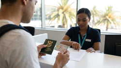 Customer handing a driving licence to an agent at a car rental desk in Miami