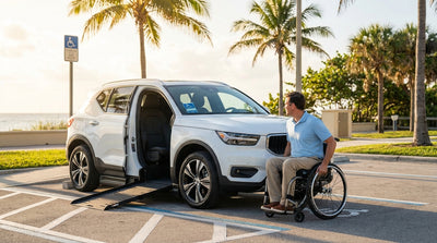 A silver car hire parked under a palm tree on a bright, sunny day at a beach in Florida