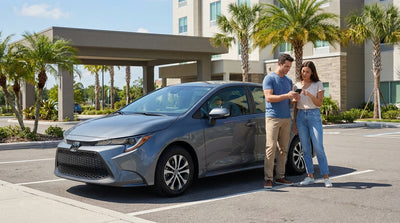 A modern electric car rental driving down a sunny, palm-lined coastal road in Florida
