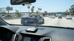 A car rental driving on a busy Los Angeles freeway with overhead signs for the express lanes