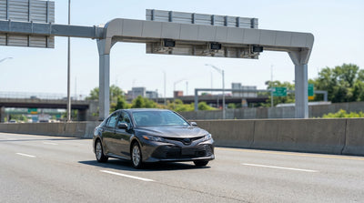 A car hire driving across a bridge toward the iconic New York City skyline on a sunny day