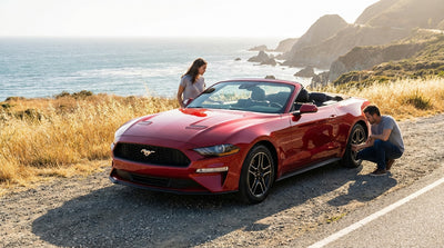 A convertible car hire drives along California's scenic Pacific Coast Highway at sunset
