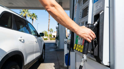 A driver refueling their car hire at a gas station pump in sunny California