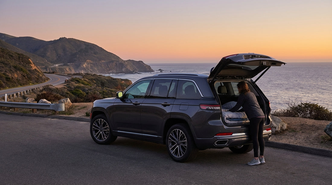 A car hire parked at a scenic viewpoint overlooking the Big Sur coast in California as the sun sets