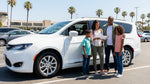 Happy driver and passenger inside a car rental driving along a scenic coastal highway in California
