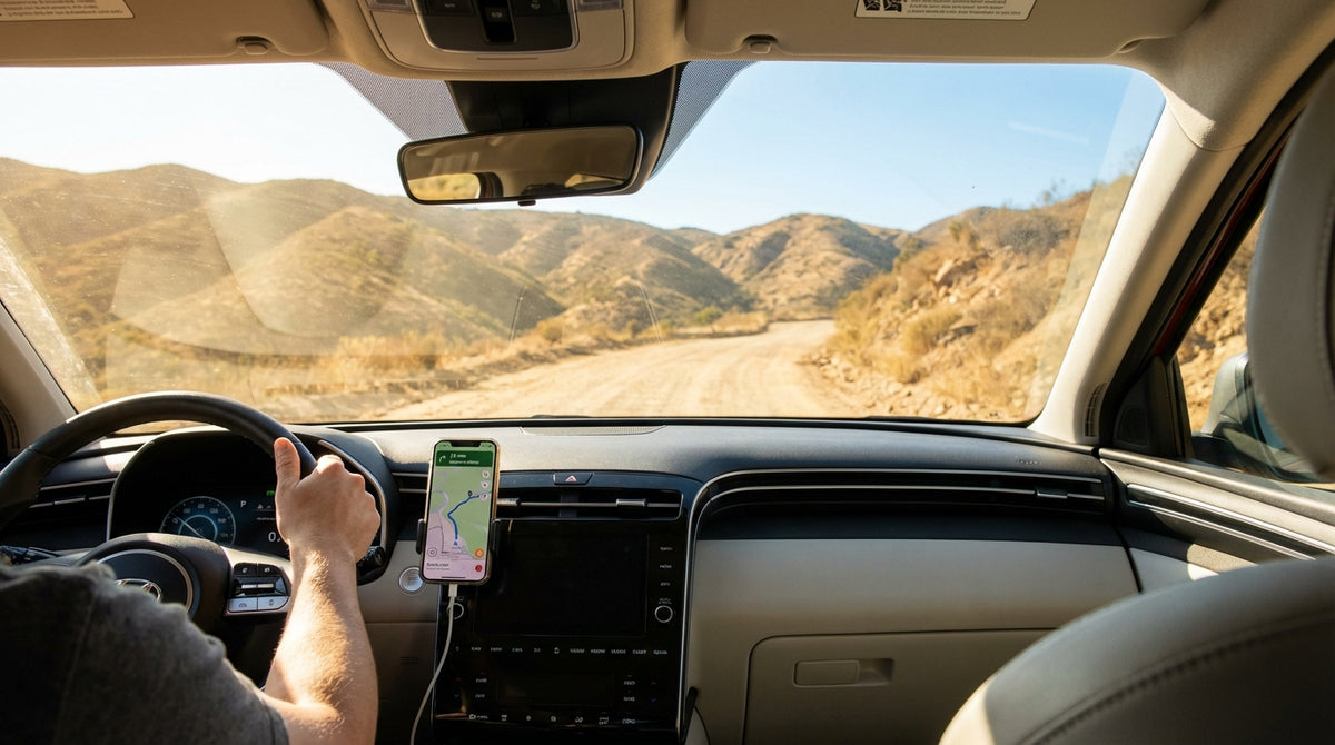 A Los Angeles car hire on a dusty, unpaved road winding through the sunlit California hills
