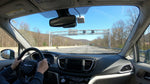 A car rental approaches an E-ZPass toll plaza on a sunny highway in Pennsylvania