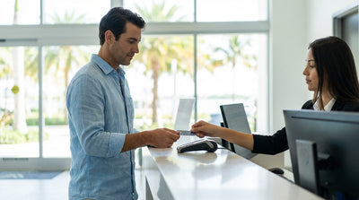 A stylish convertible car hire on Ocean Drive in Miami with its famous colorful art deco buildings in the background