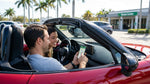 Smartphone displaying a map app mounted on the dashboard of a car rental in Florida