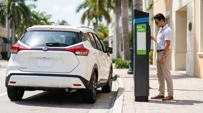 A car hire vehicle parked on a sunny, palm-lined street in Miami