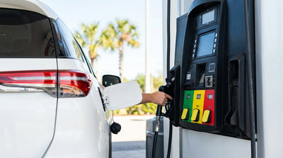 A person selects a fuel grade on a pump with 87, 89, and 93 options for their car rental at a gas station in Orlando