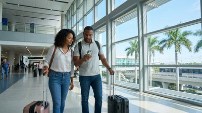A traveler follows signs for the car rental center inside a busy Miami International Airport terminal