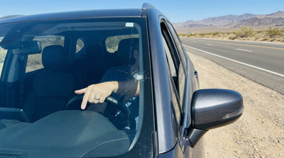 Driver's view of a stone chip on a car hire windscreen while driving on a desert highway towards Las Vegas