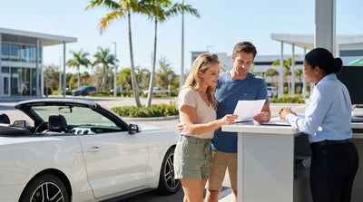 A convertible car hire driving down a scenic, palm-lined coastal highway in Florida