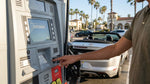 Close up of a driver using a pay-at-pump terminal next to a car rental in Los Angeles
