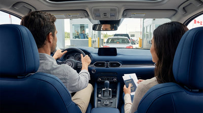 A modern car hire vehicle parked on a bustling New York street with yellow cabs and skyscrapers in the background