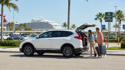 A modern car hire parked at the Port Canaveral cruise terminal with a large ship in the background near Orlando