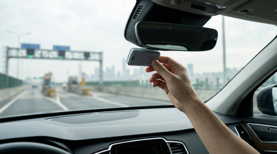 A car rental driving under a cashless toll gantry on a highway in New York on a sunny day