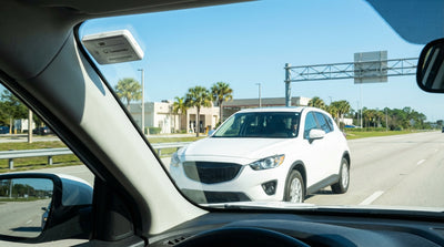 A white car rental parked at a sunny Florida Turnpike service plaza with palm trees in the background