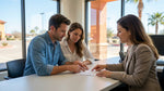 A person's hands holding a pen to sign documents at a car rental desk in Texas