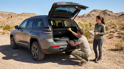 A driver inspects the spare tire of a car rental SUV on a desert highway near Las Vegas