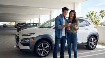 A convertible car rental drives along a sunny coastal highway in Big Sur, California