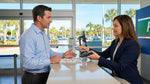Customer handing a credit card to an agent at a Florida car rental desk