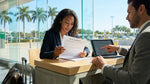 Customer signing a car hire agreement on a clipboard next to a vehicle in Miami