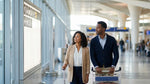 A traveler with luggage follows signs for car rental services inside JFK Terminal 8 in New York