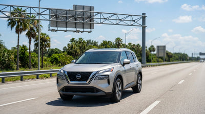 A car rental driving under an electronic toll gantry on a sunny multi-lane highway in Orlando