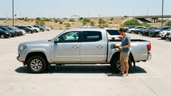 Person refueling a white car rental at a gas station in Texas