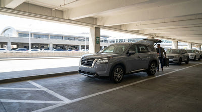 A driver's point of view from a car hire approaching the green highway signs for JFK Airport in New York