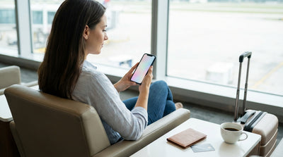 A person checks their phone while standing next to their car hire vehicle at a scenic viewpoint in the United Estates