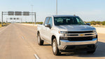 White car rental driving under an electronic toll gantry on a Texas highway