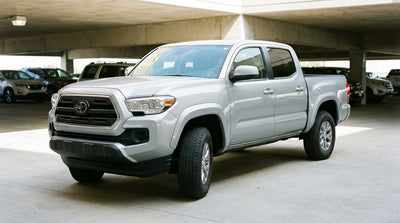 A red convertible car hire drives down a palm-lined boulevard in sunny Los Angeles