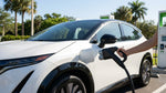 Close up of an EV charging connector plugged into a white electric car rental in Florida