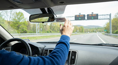 E-ZPass transponder on the windshield of a car rental driving through a Pennsylvania Turnpike toll plaza