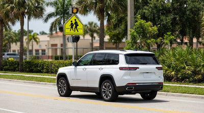 A car rental drives past a school zone speed limit sign on a sunny road in Florida